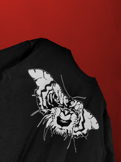 close-up on the black oversized t-shirt back graphic featuring a white tiger face merged within a butterfly, showcasing the Dauntless design